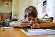 © Rob and Julia Campbell/Stocksy - Young boy coloring on the floor at home