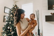 Mom And Baby In Front Of Christmas Tree