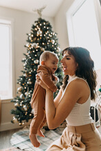 Mom And Baby In Front Of Christmas Tree