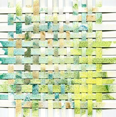 Stripes of watercolor and colored pencils colored paper weaved together 