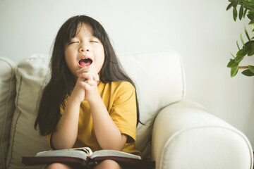 Poster - Asian kid girl read bible study.Worship at home.Sunday school.Bible on kid hands.Family christian ,Reading bible study.Hands holding on a Holy Bible.faith, spirituality and religion.child Pray online.