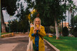 © Eloisa Ramos/Stocksy - senior woman smiling using her phone at park