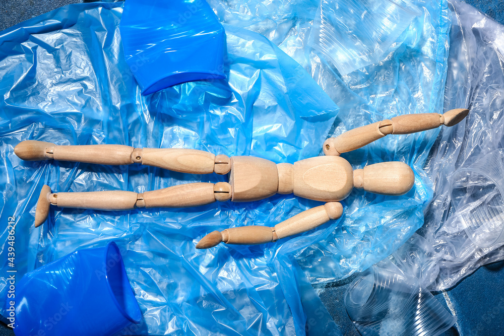 Mannequin lying on garbage, top view. Ecology concept