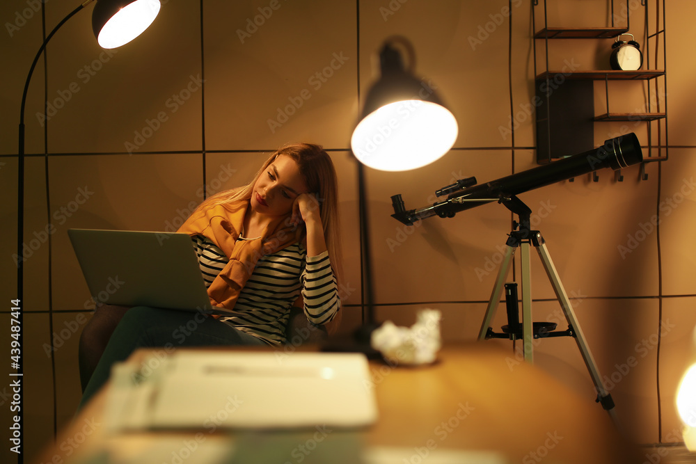 Female student preparing for exam at home late in evening