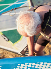 Old Man Preparing The Surf Equipement