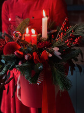 Christmas Decoration In Red Colors Which  Person In Red Cloth Holds In Hands