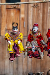 Wall Mural - Colorful puppets in a tourist stall on the street market in Burma, Myanmar. Handmade dolls hanging on display store