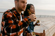 © Valentina Barreto/Stocksy - couple sitting on city port having lunch and drinking beer