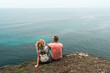 © Alexander Grabchilev/Stocksy - Romantic Couple Sitting On A Cliff