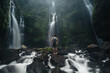 © Alexander Grabchilev/Stocksy - the traveler stands at the waterfall in the jungle