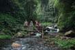 © Alexander Grabchilev/Stocksy - tourists stand on the bridge over the river in the jungle