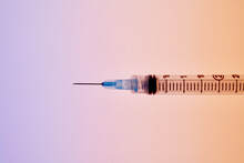 Medical Syringe On Blue-Orange Background 