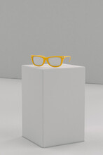Yellow Sunglasses On Grey Parallelepiped