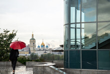 Anonymous Woman With A Red Umbrella Walks In Moscow Next To An Orthodox Church