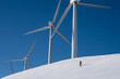 © Hakan & Sophie/Stocksy - a  person skiing at a wind farm