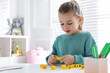 © New Africa - Little girl assembling word with yellow bricks in classroom at English lesson