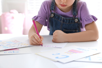 Canvas Print - Little girl writing numbers in classroom at English lesson, closeup