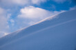© Hakan & Sophie/Stocksy - snow dune and puffy cloud