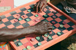 © Ogoh Clement/Stocksy - Men playing Draft board game