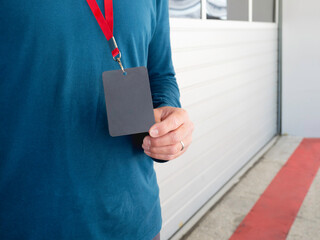 Man with badge on red ribbon stays on pit lane at autodrom. Sports car racing. Sports competition on special track.