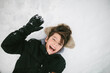 © Maria Manco/Stocksy - overhead view of boy laughing in snow