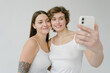 © Roman Shalenkin/Stocksy - Smiling young women taking selfie on smartphone