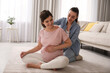 © New Africa - Doula working with pregnant woman in living room. Preparation for child birth