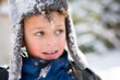© Jennifer Bogle/Stocksy - rosy cheeked boy with face full of snow