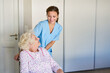 Altenpflegerin kümmert sich um Seniorin im Rollstuhl