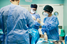 Unrecognizable Surgeon With Assistants During Operation In Clinic