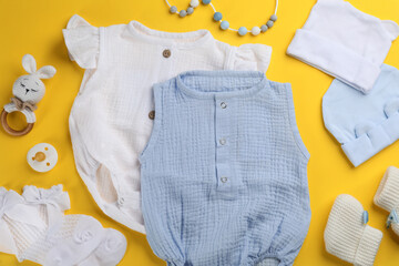 Wall Mural - Flat lay composition with baby clothes and accessories on yellow background