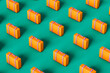© Giada Canu/Stocksy - pattern of multiple orange suitcases on green background