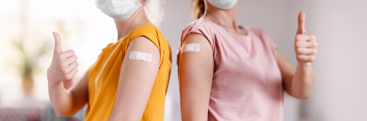 Women showing thumbs up after inoculation against Covid 19.