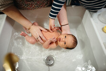 Giving Baby A Bath In The Kitchen Sink
