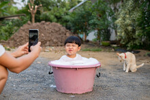 Asian Boy Take A Bath In Plastic Basin