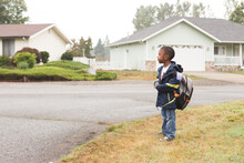 Boy Waits With Backpack At Bus Stop