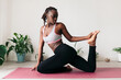 © Lucas Ottone/Stocksy - Black woman practicing yoga at home