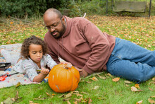  Girl Carves Pumpkin While Father Supervises