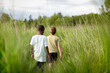© Jennifer Bogle/Stocksy - Brothers stride through field of tall grass