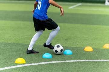 Asian teenager Football Players In Blue practicing football at the training ground