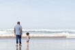 © Jennifer Bogle/Stocksy - Father and daughter walk in ocean