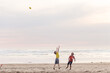 © Jennifer Bogle/Stocksy - Brothers compete to catch football on beach