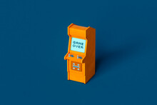 A Single Orange Arcade Cabinet On Blue Background