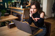 © F8  \ Suport Ukraine - Attractive shocked upset young brunette woman sitting at the cafe table with laptop computer indoors