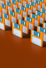 Multiple Blue And Orange Floppy Disks On Brown Background