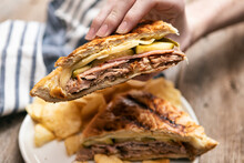 Hand Holding Delicious Traditional Cuban Pressed Sandwich