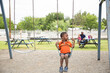 © Jennifer Bogle/Stocksy - Black boy with dusty legs on swing