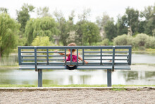 Toddler Sitting On Geometric Park Bench