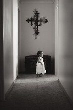 Girl In White Dress In Hall With Crucifix