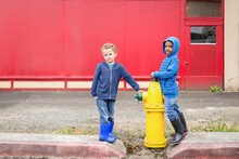 Brothers Play By Fire Hydrant Near Red Wall